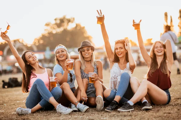 happy girlfriends enjoying start of the weekend on music festival