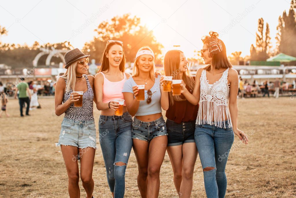 happy girlfriends enjoying start of the weekend on music festival 