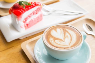 sıcak yeşil çay süt Kupası ve kahve fincanı ve Çilekli pasta 