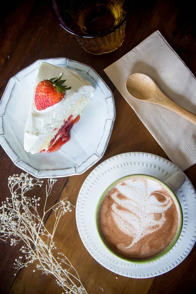Coffee cup a jahodový dort v kavárně s dřevo pozadí — Stock fotografie