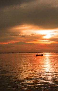 Deniz akşam güneş batımında. kırmızı güneş ışığı deniz ve tekne