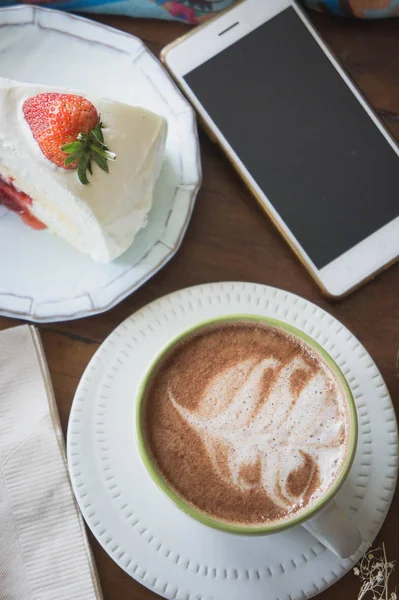 Šálek kávy a jahodový dort v kavárně, káva uvolnit čas — Stock fotografie