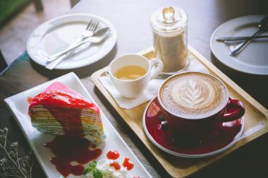 latte sanat ve lezzetli kek ahşap masa üzerine fincan kahve aroması kırmızı 