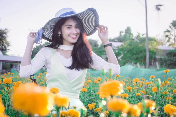 Stile asiatico donna beatiful sul giardino giallo fiore e guardando sorridere tempo felice il giorno — Foto Stock