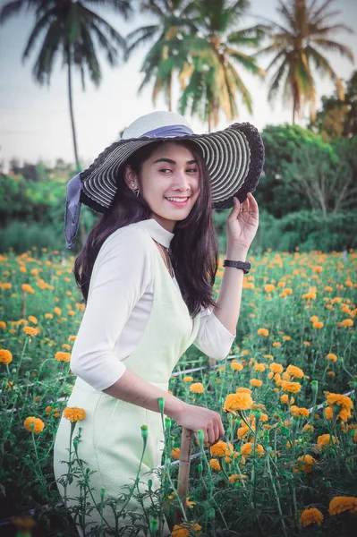 黄色の花畑と日の笑顔幸せな時間を探している美しい女性アジア スタイル — ストック写真