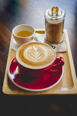 latte sanat ve lezzetli kek kafede vintage koyu tonu ve kopya alanı olan ahşap masa üzerine fincan kahve aroması kırmızı