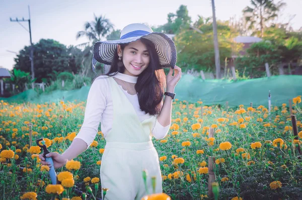 Stile asiatico donna beatiful sul giardino giallo fiore e guardando sorridere tempo felice il giorno — Foto Stock