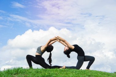 Kadın pratik yoga dinlenmek doğa ve mavi gökyüzü arka plan