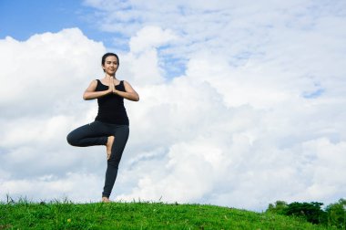 Kadın pratik yoga dinlenmek doğa ve mavi gökyüzü arka plan