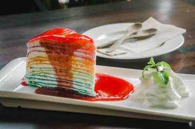 Gökkuşağı pasta üzerinde ahşap masa yemeye hazır