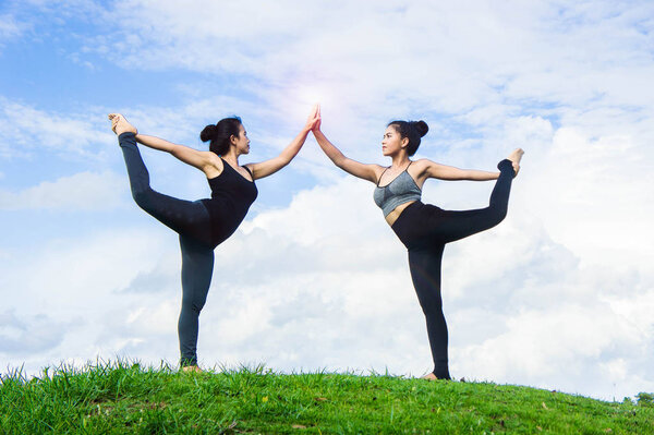 Женщина практикующая йогу расслабиться на природе и голубом фоне неба
