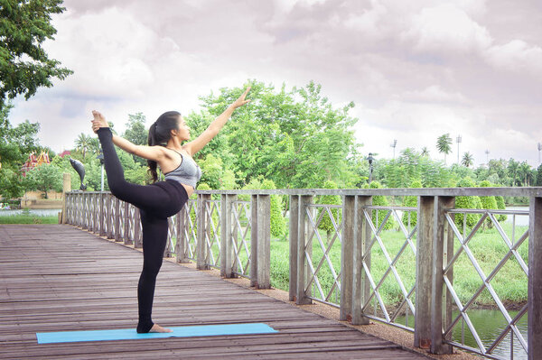 Женщина практикующая йогу расслабиться на природе и голубом фоне неба
