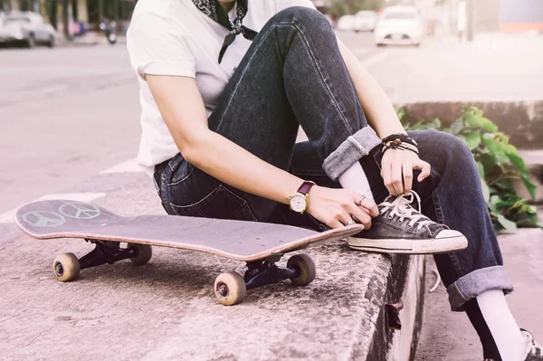 Asian Teen Girl With Skateboard style in outdoors skate park street with dark vintage tone style