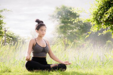 Genç kadın pratik yoga her gün Yoga yardımcı konsantrasyon nefes, vücut şekli, gücü, yardım cilt aydınlatmak. Parlak gün arasında Dharma havada