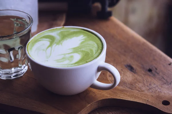 Groene thee warm drankje latte witte cup op houten tafel aroma ontspannen tijd in coffeeshop — Stockfoto