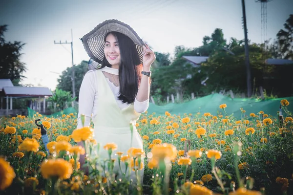 Schöne Frau asiatischen Stil auf gelben Blumengarten und suchen Lächeln glückliche Zeit am Tag — Stockfoto