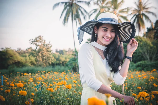 黄色の花畑と日の笑顔幸せな時間を探している美しい女性アジア スタイル — ストック写真