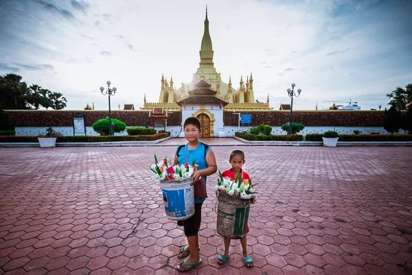 15. Juli 2019, Laos, kleiner Junge und kleines Mädchen warten darauf, dass Touristen Blumen kaufen — Stockfoto