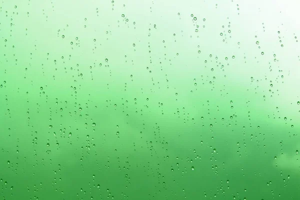 Gouttes d'eau abstraites vertes sur le fond de verre — Photo