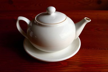 Beyaz demlik ve fincan tabağı yalnız ahşap tablo