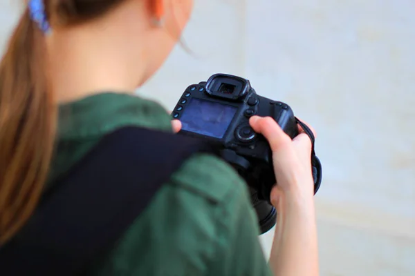 Girl photographer look at camera in her hands