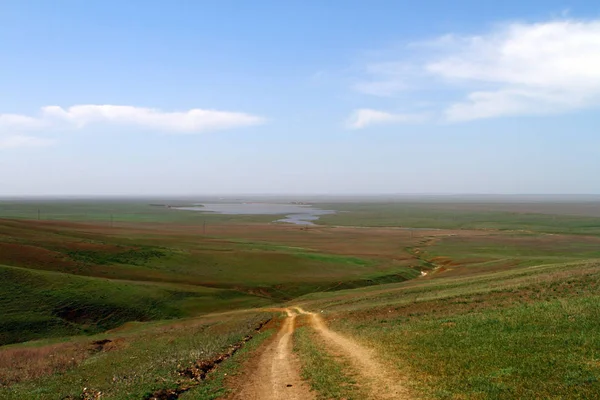 Unpaved dry dirt country road in spring steppe, offroad drive