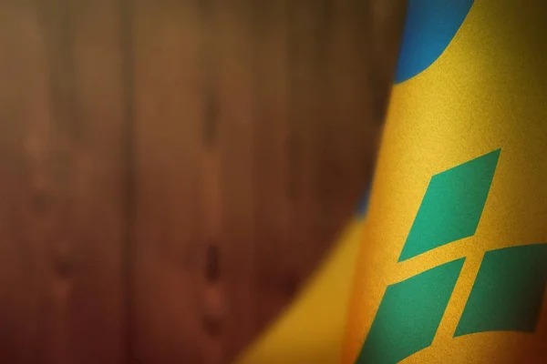 Saint Vincent en de Grenadines vlag ter ere van veteranen dag of herdenkingsdag. Glorie aan de Saint Vincent en de Grenadines helden van de oorlog concept op rood wazig natuurlijk hout muur achtergrond. — Stockfoto