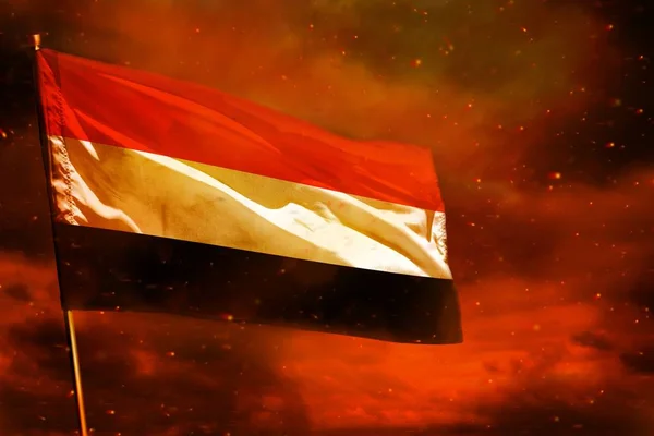 Ondeando la bandera de Yemen en el cielo rojo carmesí con el fondo de los pilares de humo. Concepto de problemas . —  Fotos de Stock