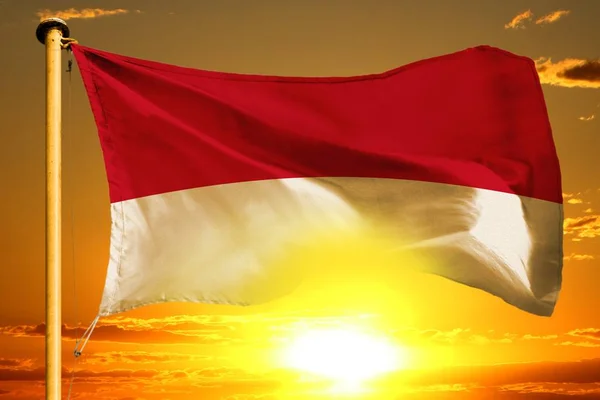 Bandera de Indonesia tejiendo en la hermosa puesta de sol naranja con las nubes de fondo —  Fotos de Stock