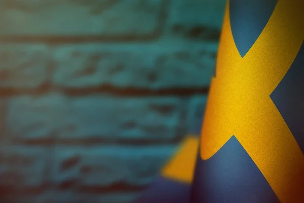 Sweden flag for honour of veterans day or memorial day. Glory to the Sweden heroes of war concept on light blue blurred painted brick wall background.