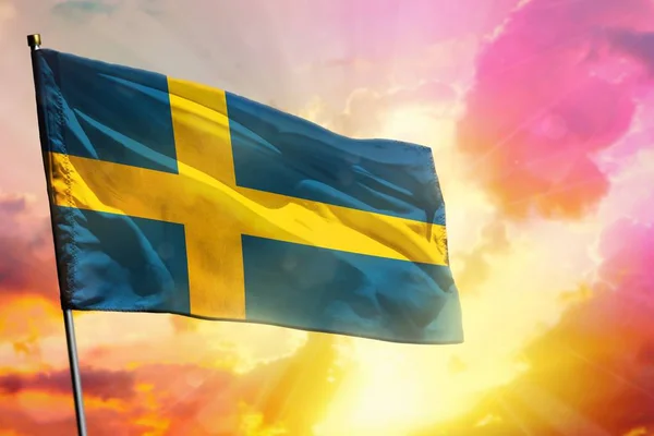 Fluttering σημαία της Σουηδίας για όμορφο πολύχρωμο ηλιοβασίλεμα ή την ανατολή του ηλίου φόντο. Έννοια επιτυχίας. — Φωτογραφία Αρχείου
