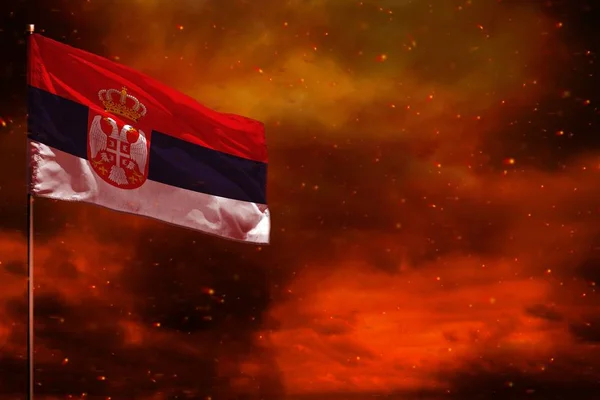 Fluttering Sérvia bandeira mockup com espaço em branco para o seu texto no céu vermelho carmesim com fundo pilares de fumaça. Conceito de problemas . — Fotografia de Stock