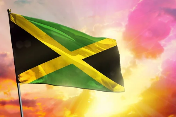 Fluttering Jamaica zászló gyönyörű színes naplemente vagy napkelte háttér. Sikerkoncepció. — Stock Fotó