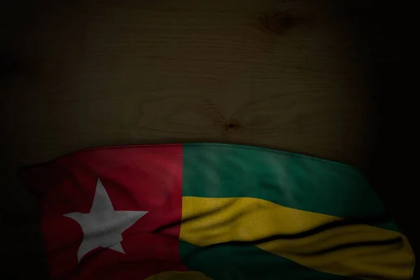 Merveilleuse image sombre du drapeau togolais avec de grands plis sur du bois sombre avec un endroit vide pour votre contenu - toute illustration 3d drapeau de vacances — Photo