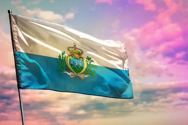 Fluttering San Marino bandeira no fundo do céu nublado colorido. Conceito de prosperidade . — Fotografia de Stock