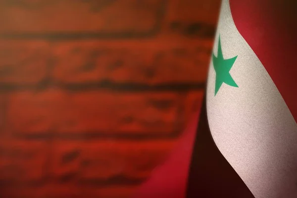 Прапор Сирійської Арабської Республіки на честь ветеранів дня або пам'ятника. Слава героям війни Сирійської Арабської Республіки на червоному розмитому пофарбованому цегляному фоні.. — стокове фото