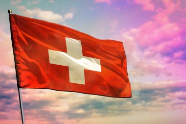 Fluttering Switzerland flag on colorful cloudy sky background. Prosperity concept.