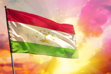 Güzel gün batımı ya da gündoğumu arka planında dalgalanan Tacikistan bayrağı. Tacikistan başarı ve mutluluk kavramı.