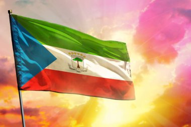 Renkli günbatımında ya da gündoğumu arka planında dalgalanan Ekvator Ginesi bayrağı. Ekvator Ginesi başarı ve mutluluk konsepti.