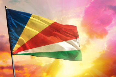 Renkli günbatımında ya da gündoğumu arka planında dalgalanan Seyşeller bayrağı. Seyşeller başarı ve mutluluk kavramı.