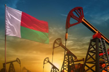 Madagaskar petrol endüstrisi konsepti, endüstriyel illüstrasyon. Mavi ve sarı günbatımı arka planında dalgalanan Madagaskar bayrağı ve petrol kuyuları - 3 boyutlu illüstrasyon