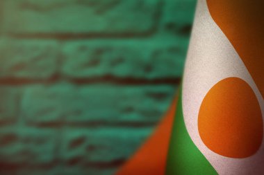 Nijer bayrağı asma günü ya da deniz yeşili, bulanık tuğla duvar arkaplanındaki anma günü için. Nijer, savaş kahramanlarının zaferi..