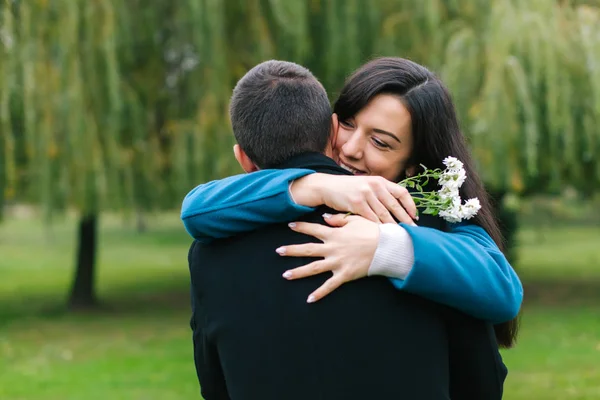 Jovem casal abraçar uns aos outros em um parque — Fotografia de Stock