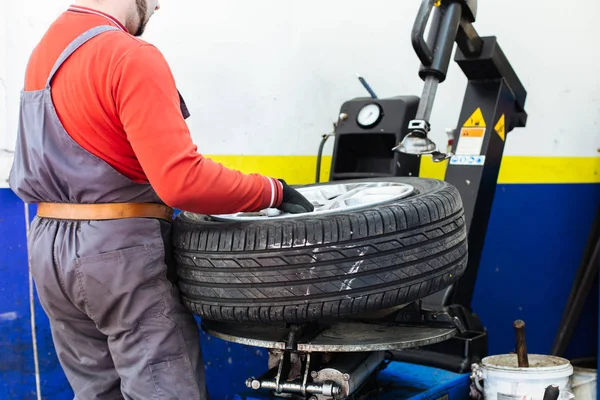 Mecânico remove pneu de carro — Fotografia de Stock