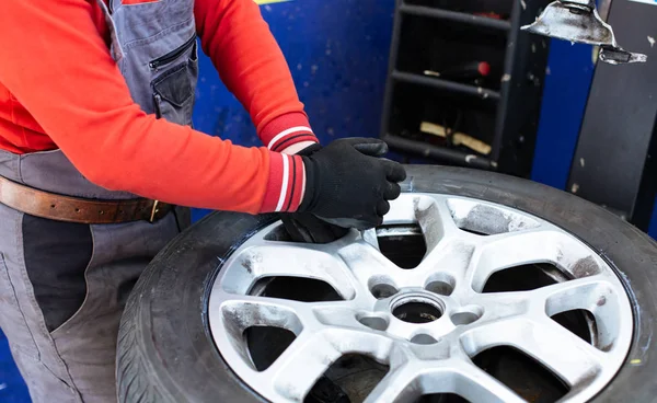 Mechanic removes car tire closeup