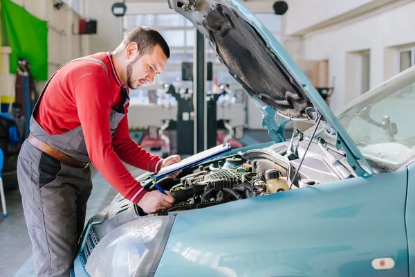 Mecânico de carro preparando checklist na oficina — Fotografia de Stock