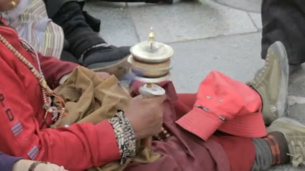 Стара жінка тримає буддійське молитовне колесо — стокове відео