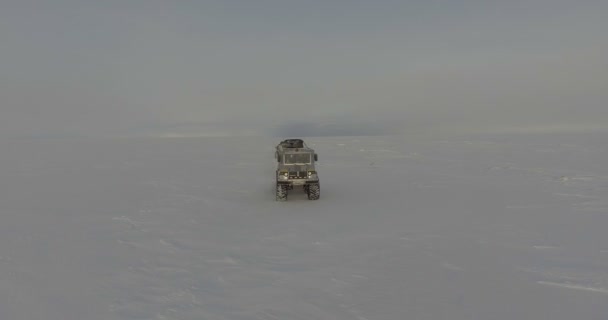 Sobrevolando vehículos todo terreno con viajeros a través del Océano Ártico Clip De Vídeo