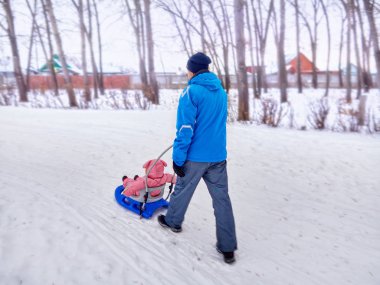Çocuk ile baba kızak kışın karda yürümek.