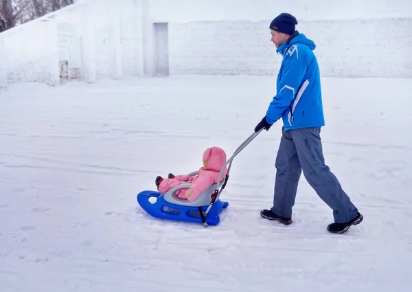 Padre con passeggiata di bambino nell'inverno la slitta su neve . — Foto Stock